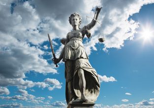 Justitia (sprich: justizia) hieß die römische Göttin für Gerechtigkeit. Heute steht sie als Statue vor vielen Gerichten