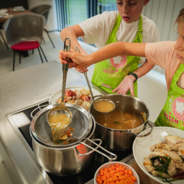 Die Suppe durch ein feines Sieb seihen. Karottenwürfel und Selleriewürfel in der Suppe weichkochen