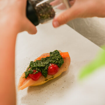 Das Gemüse auf der Hühnerbrust verteilen. Mit Pesto, frischen Kräutern oder Tomatensauce verfeinern.